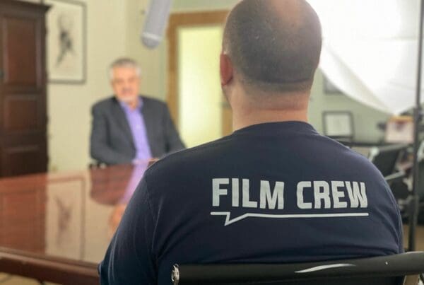 A man in a chair wearing a film crew shirt.