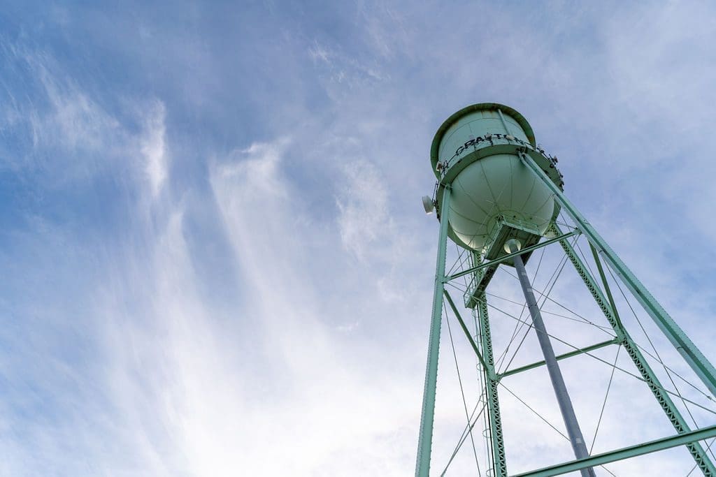 A water tower against a blue sky in Grafton, ND.