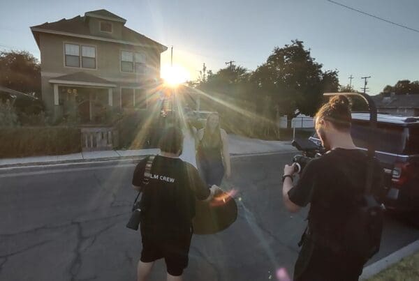 Sunlight streams past a house as Jordan and Duncan film a woman.