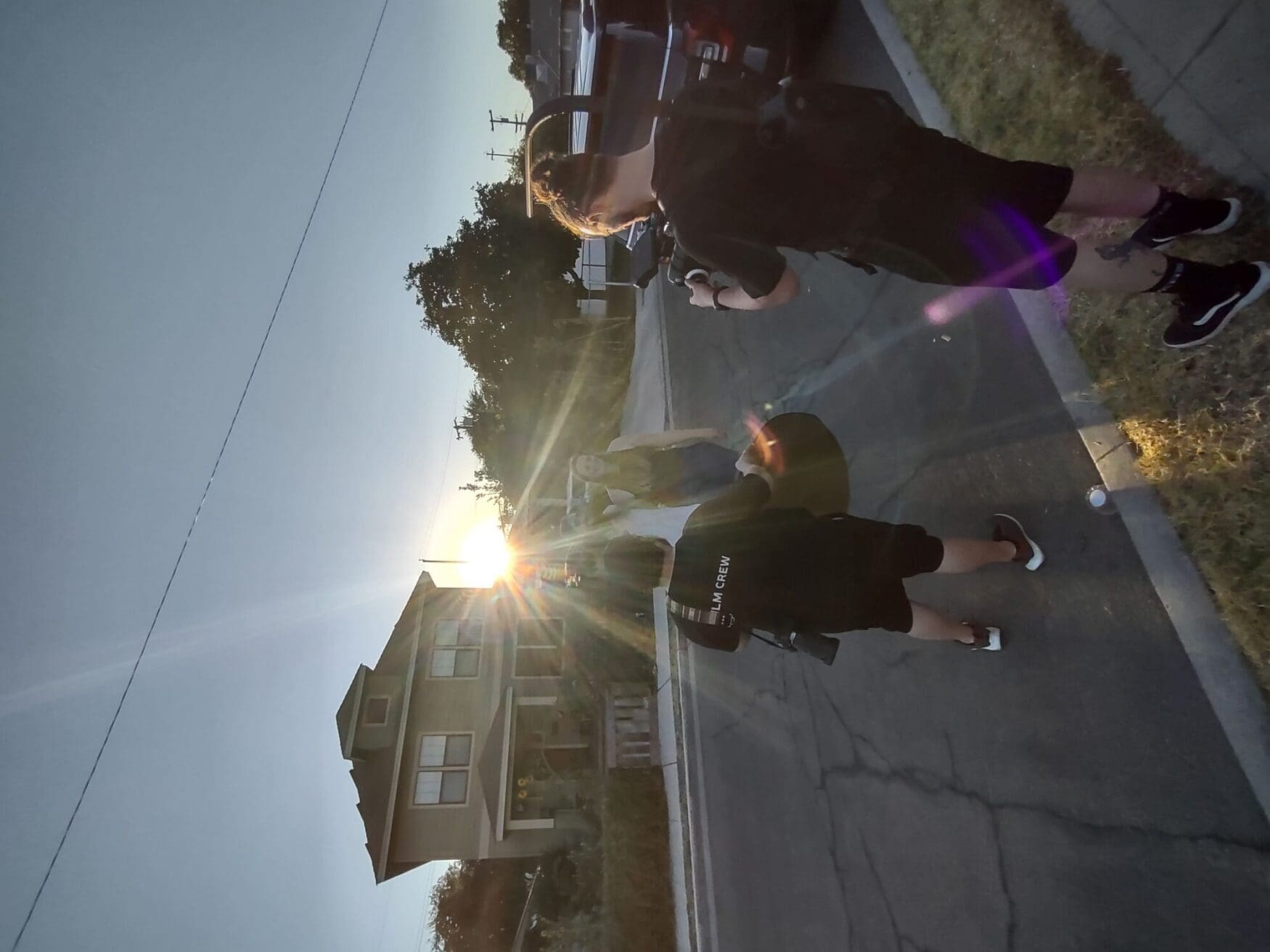 Sunlight streams past a house as Jordan and Duncan film a woman.